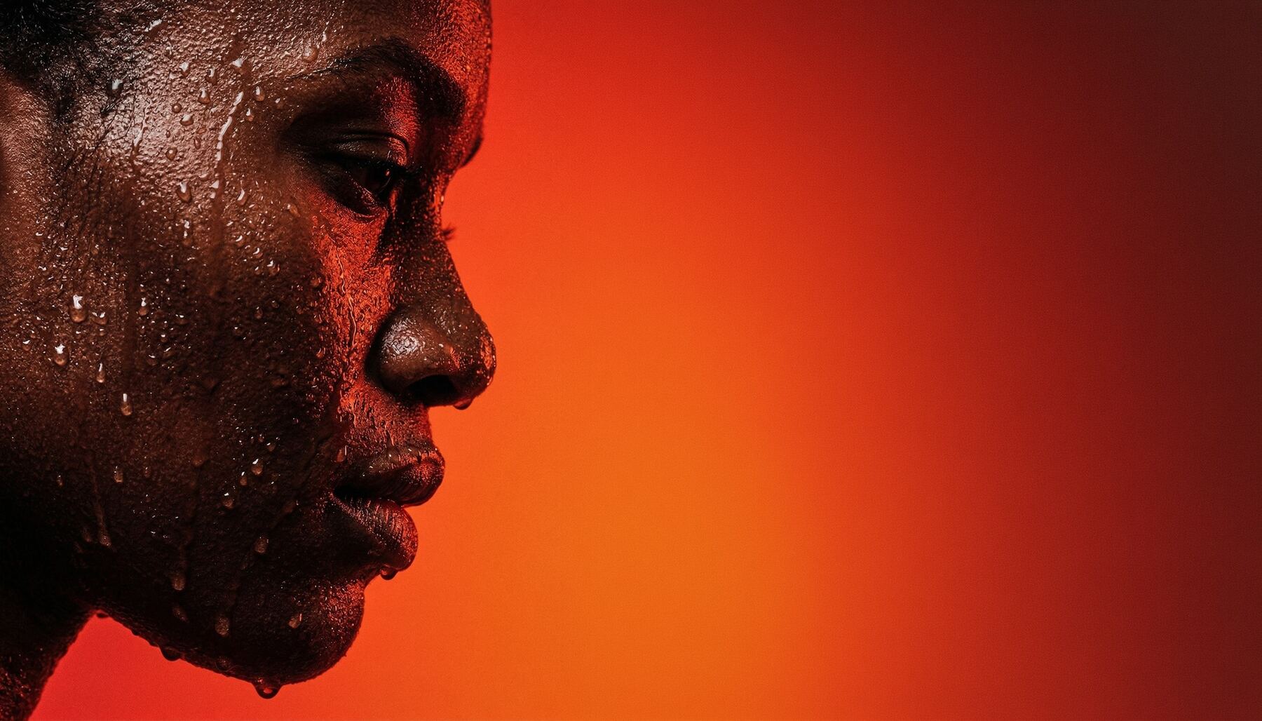 Rostro con gotas de sudor sobre fondo naranja